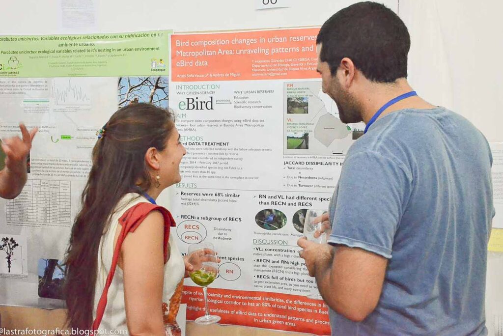 Dos personas frente a un poster científico durante la Reunión Argentina de Ornitología de Tandil